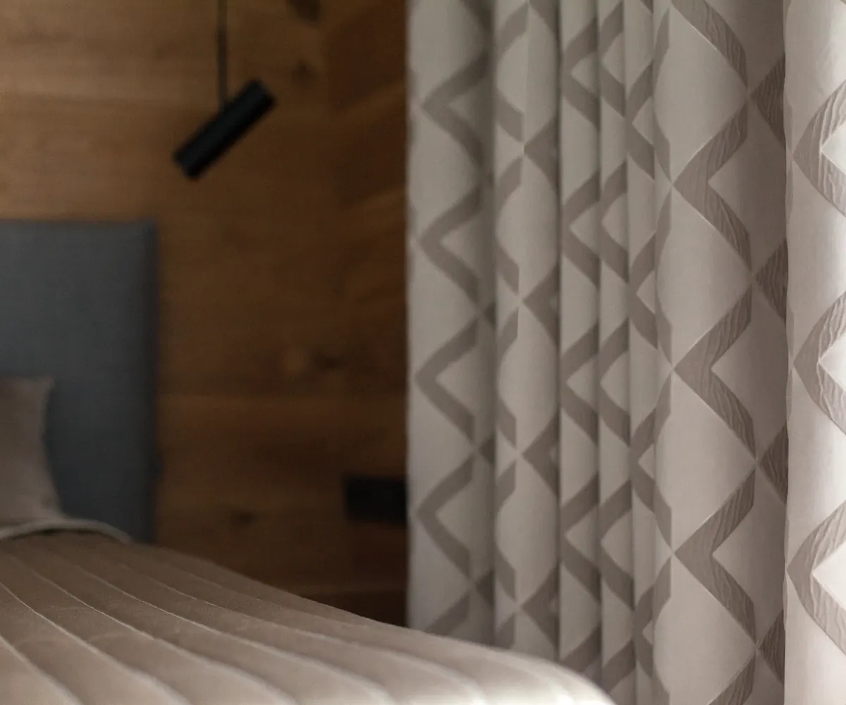 Bedroom with patterned curtains and neutral bedding