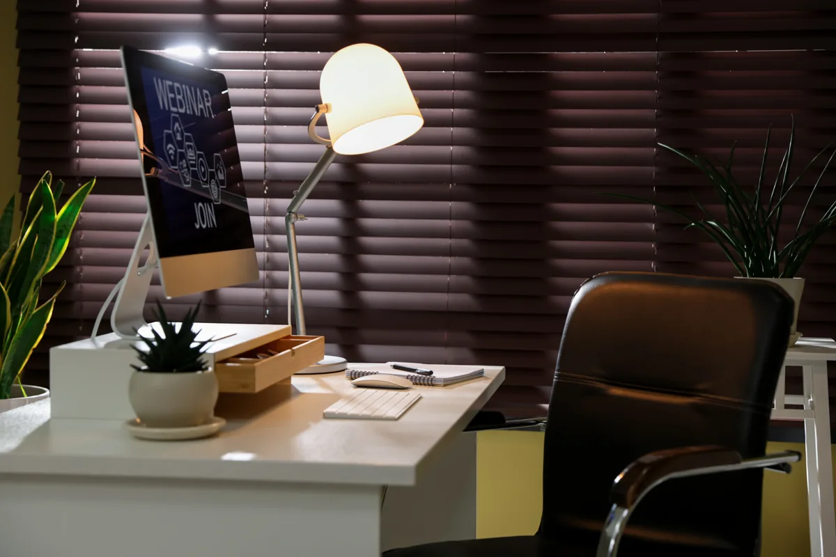 Office with wood blinds and a desk