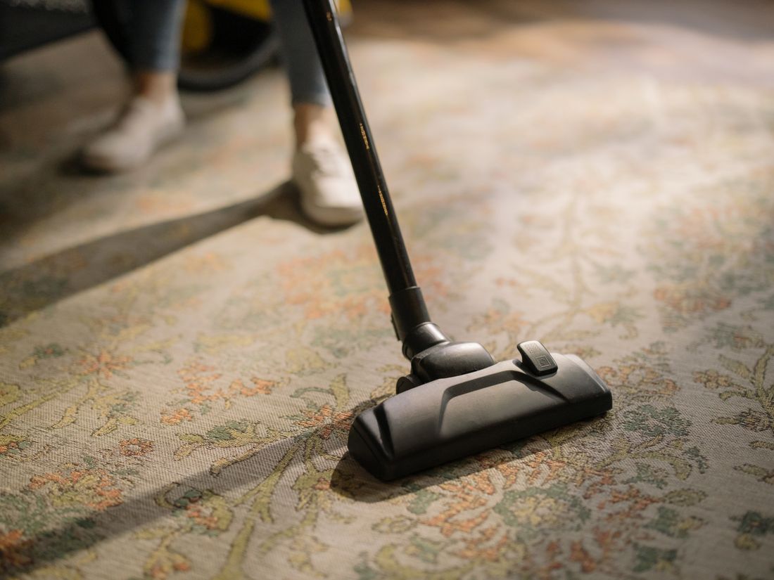 A vacuum cleaner moving over a patterned rug