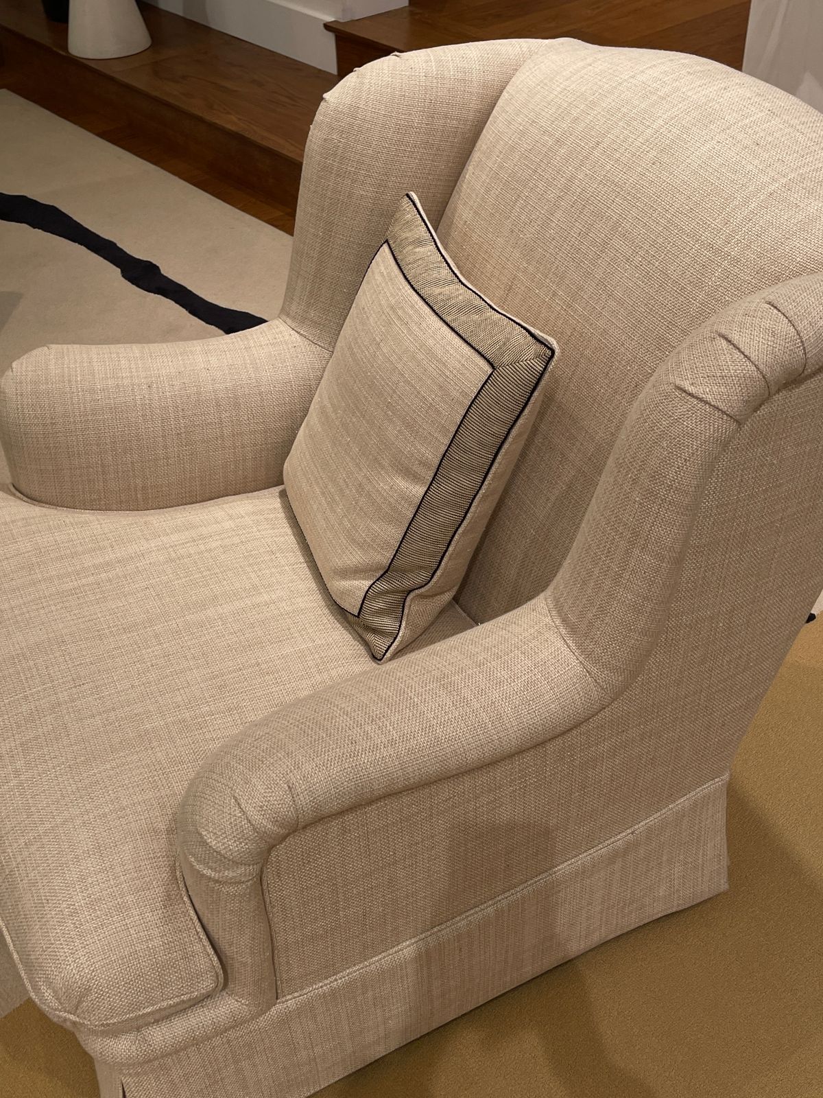 Neutral upholstered armchair with a matching cushion